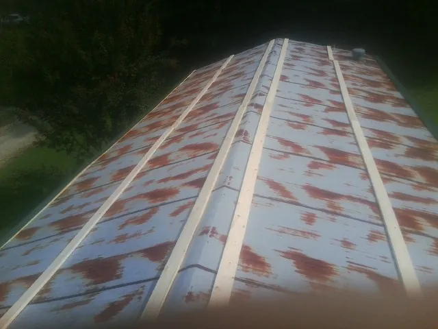Rusted metal roof panels with new wood purlins before replacement — Storm Damage Roof Repair in Arlee by Roofing Brothers